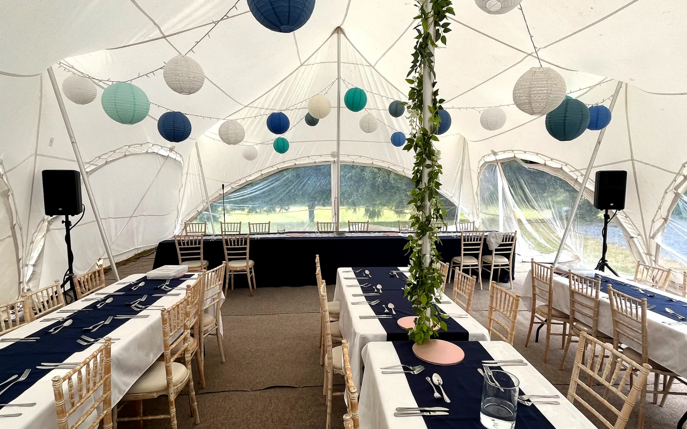 Wedding marquee laid for dinner under lanterns